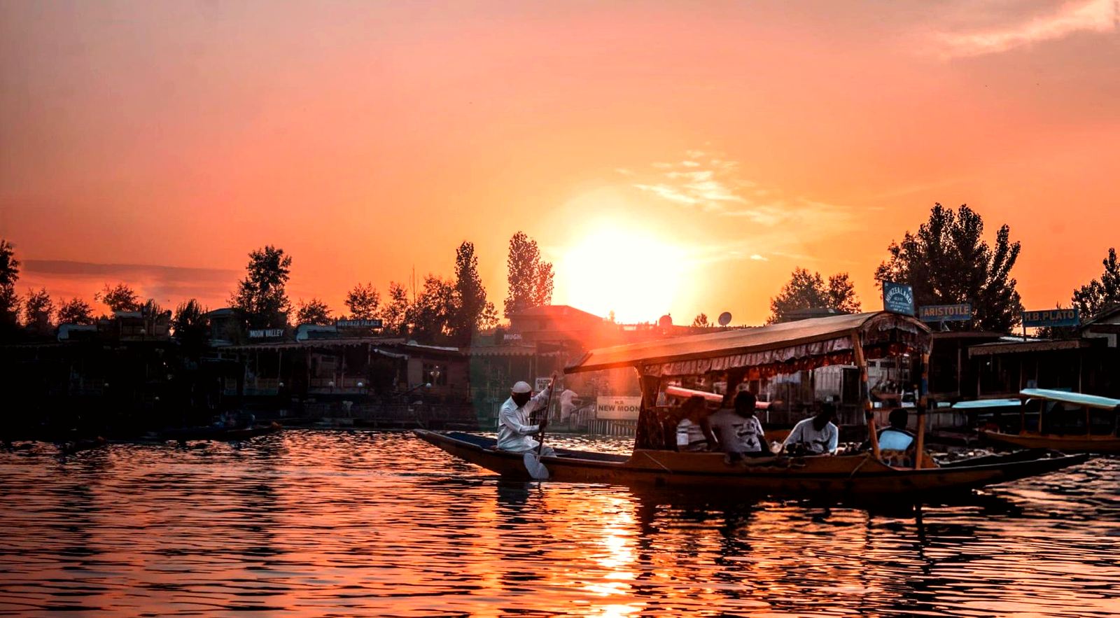 Shikara boat silhouetted against a sunset sky on Dal Lake, Srinagar